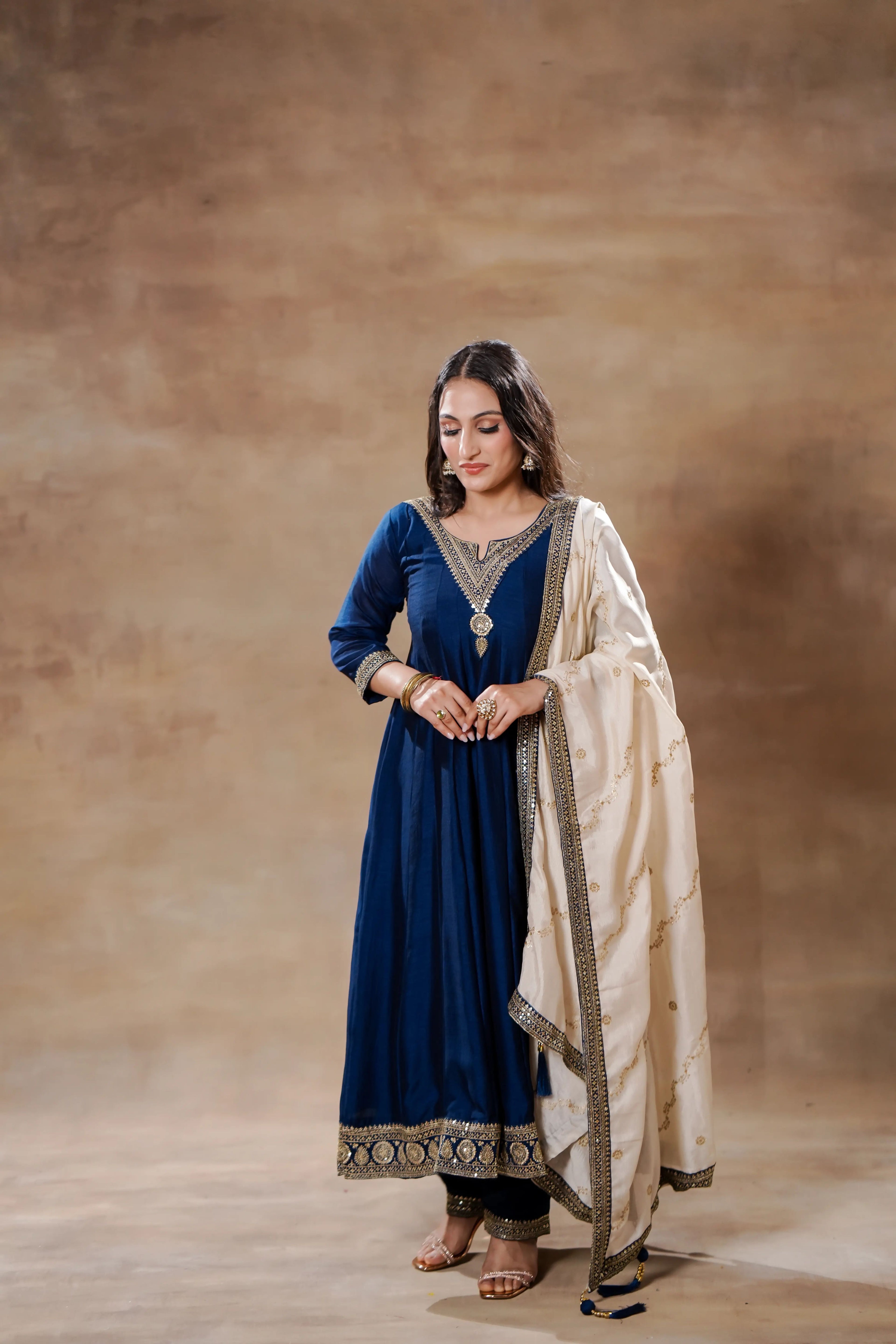 Midnight blue silk Anarkali dress with intricate embroidery, paired with an ivory dupatta from Shuchi Man.