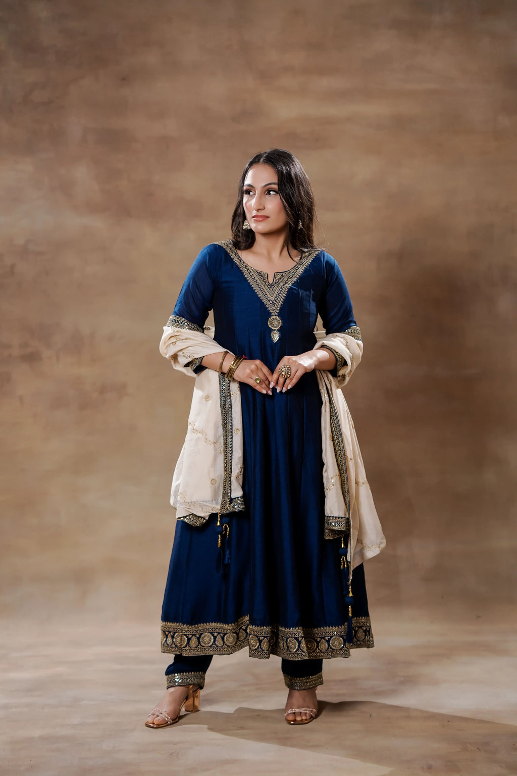 Midnight blue silk Anarkali suit with ivory dupatta by Shuchi Man, featuring intricate embroidery and flowing fabric.