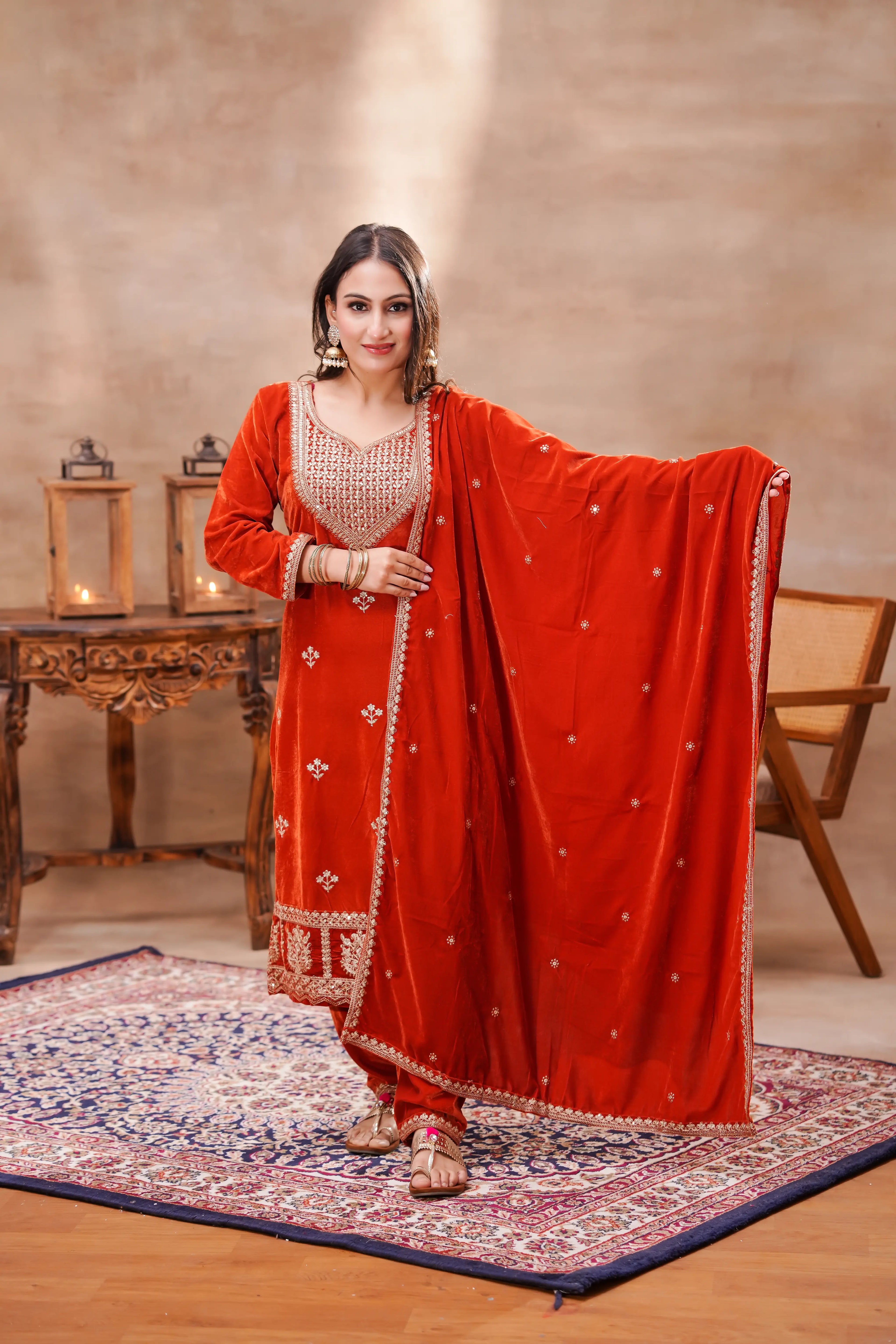 Rust-orange velvet embroidered suit set with kurta, matching dupatta, from Shuchi Man, featuring intricate embroidery and luxurious fabric.