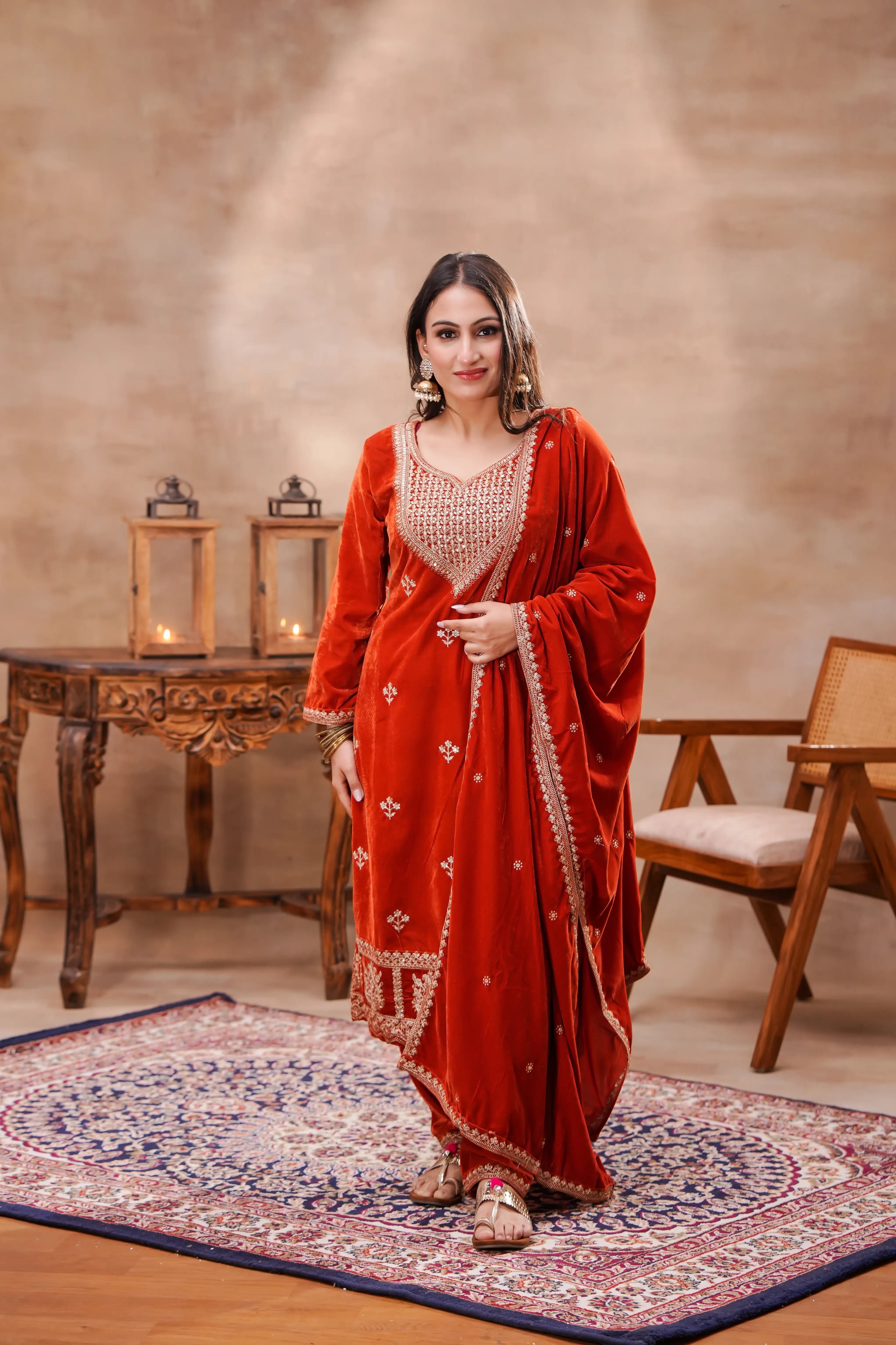 Rust-orange velvet embroidered suit set by Shuchi Man featuring a detailed kurta with matching bottoms and dupatta.