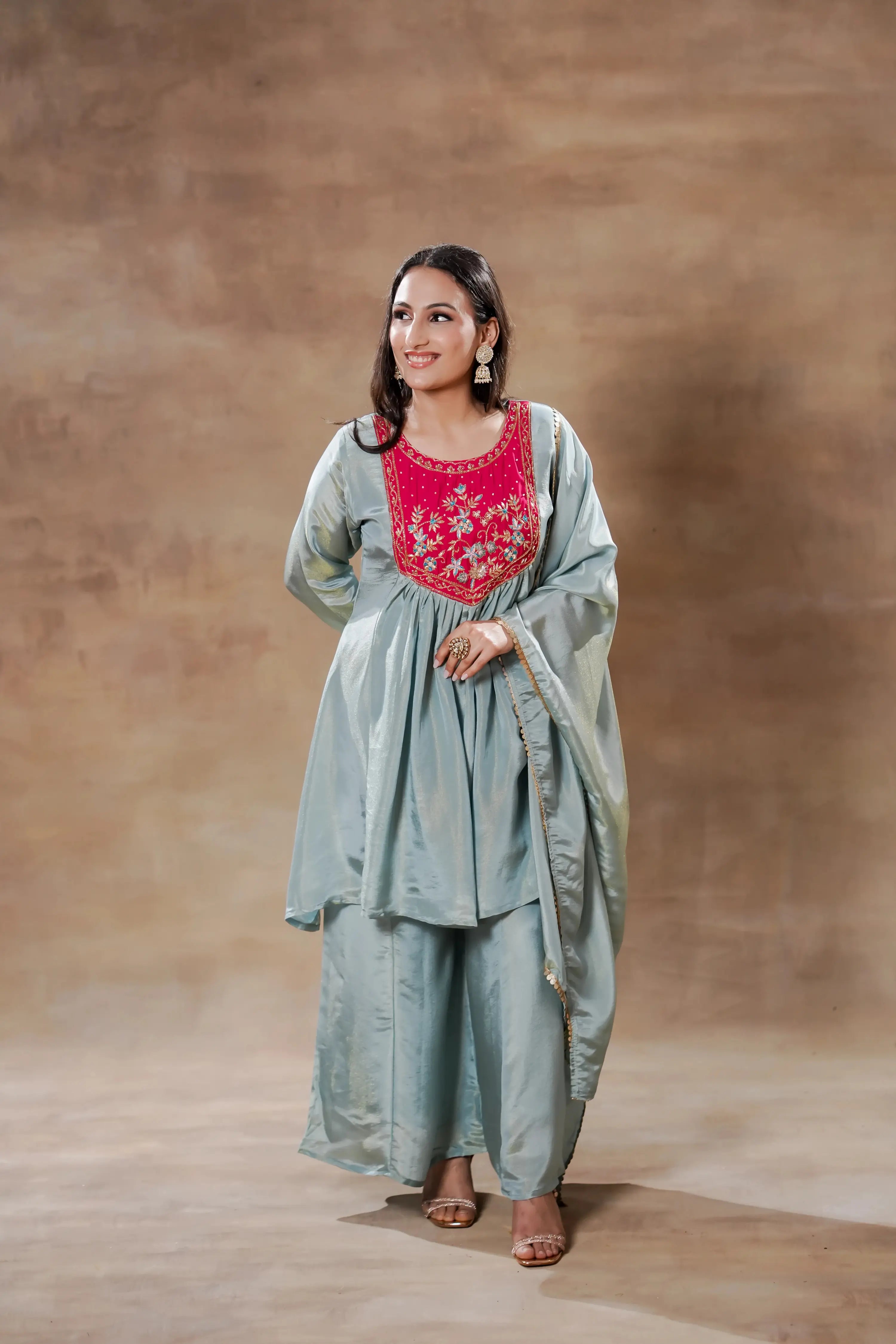 Sky-blue and pink satin silk Anarkali set by Shuchi Man featuring intricate embroidery and flowing fabric.